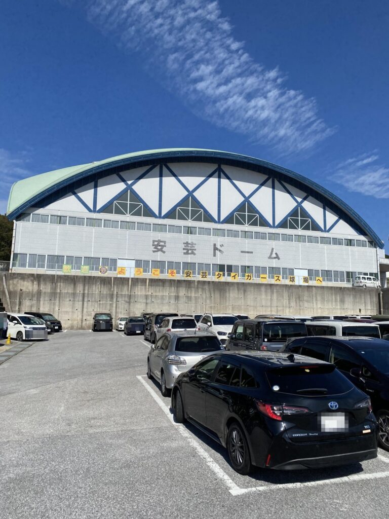 11時台の安芸ドームと駐車場。青空の下、駐車場に車が並んでいる（ナンバーはモザイク）