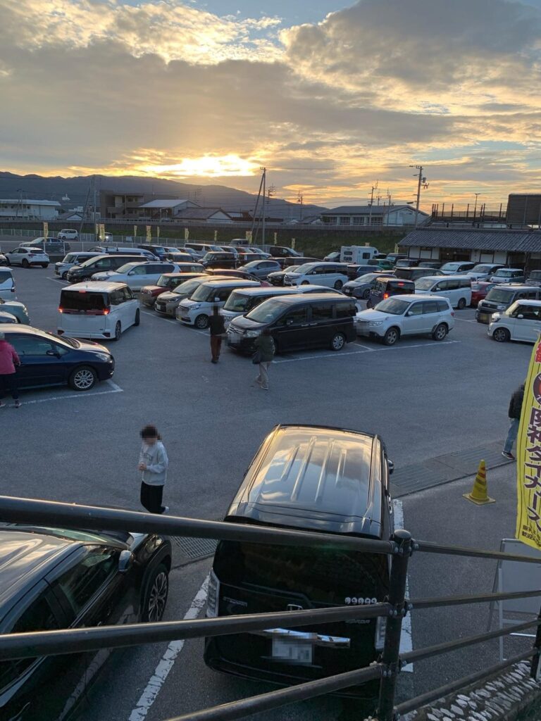 朝日がのぼる6時55分ごろの駐車場。ほとんどの場所に車が停まっている（ナンバーと人の顔はモザイク）