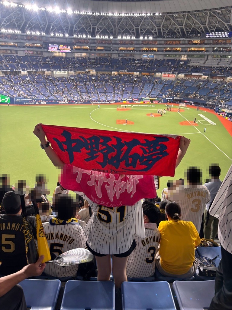 京セラドームのレフトスタンドで中野拓夢選手のタオルを広げる阪神ファンと、まわりの阪神ファン